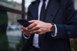 © Novak - Cropped image of businessman using smartphone