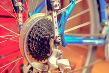 Detail Of Change- Speed On Bicycle. Bike Speed Changing Assembly. Rear Wheel. Steel Bicycle Chain. Transmission Gears Close-up