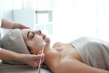 Poster - Cosmetologist applying mask on client's face in spa salon