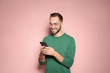 © New Africa - Handsome young man with mobile phone on color background