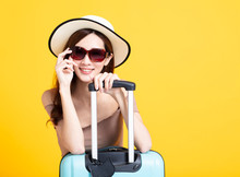 Happy Tourist Woman In Summer Hat Holding  Sunglasses And Suitcase