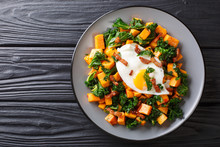 Delicious Breakfast Of Sweet Potato With Kale, Bacon And Fried Egg Close-up On A Plate. Horizontal Top View
