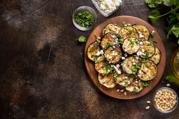 Wall Mural - Fried eggplant with feta, pine nuts, fresh herbs (cilantro, parsley) and olive oil. Tasty vegetable snack, summer, spring food, picnic