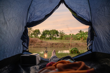 Wall Mural - View from inside of tent with relaxing and campfire near swamp