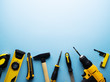 © Aboltin - Creative provocation: a flat layout of yellow hand tools on a blue background.