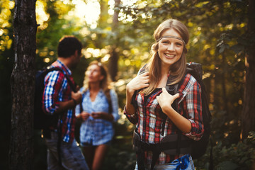 Wall Mural - group of people hiking in forest and smiling