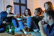 © Syda Productions - friendship, and leisure concept - happy friends with non-alcoholic drinks and snacks watching tv at home in evening
