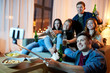© Syda Productions - friendship, people, technology and party concept - happy friends with non-alcoholic drinks taking picture by selfie stick at home in evening