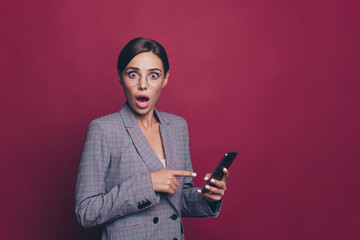 Wall Mural - Portrait of her she nice cute attractive lovely sweet winsome impressed lady wearing gray checkered jacket pointing at new device gadget  isolated over maroon burgundy marsala background