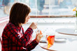 © Iryna - Portrait of teenager boy drinking tea with dessert having breakfast in cafe.