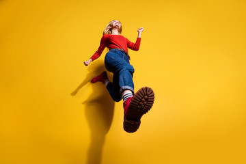 Low below angle full length body size view of nice attractive cheerful girl having fun going making step wearing vintage retro maroon boots isolated over bright vivid shine orange background