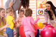 © Oksana Kuzmina - Mothers with little kids doing exercises with red gymnastic ball at gym. Concept of caring for the baby's health.