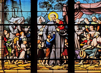 Saint Vincent de Paul gathering with the Daughters of Charity abandoned children, stained glass window in Saint Severin church in Paris, France