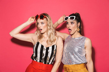 Poster - Photo of two excited women 20s in trendy outfit and sunglasses smiling at camera