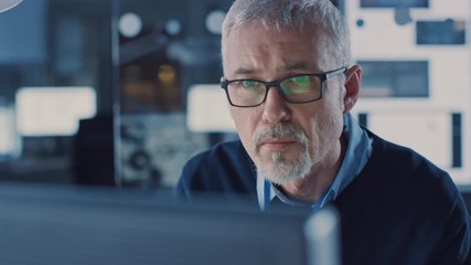 Fototapete - Portrait of Handsome Middle Aged Engineer Wearing Glasses Works on Personal Computer. In the Background High Tech Engineering Facility