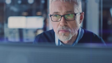Poster - Portrait of Handsome Middle Aged Engineer Wearing Glasses Works on Personal Computer. In the Background High Tech Engineering Facility