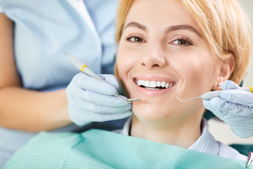 Dentist checks the teeth of a girl