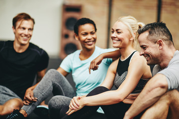 Smiling group of diverse friends sitting together in a gym