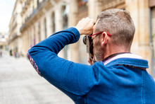Rear View Of A Photographer Man Taking Photo In The Street