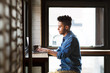 © Cavan Images - Side view of man using laptop at cafe
