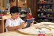 © Cavan Images - Boy using tablet computer while sitting in workshop