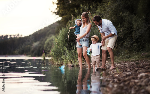 Cuadros en Lienzo A young family with two toddler children outdoors by the river in summer