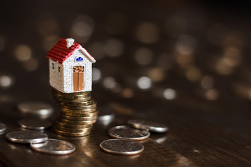 Model house on stack of coins. Concept of Investment management