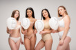 four attractive multiethnic women in lingerie holding air balloons with 