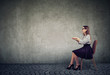 © Feodora - elegant woman sitting at invisible table pretending to type on computer