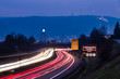 © Westend61 - Germany, Stuttgart, Warning sign for particulate pollution alert and traffic in the evening