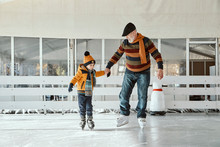 Grandfather And Grandson On The Ice Rink, Ice Skating