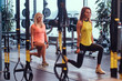 © Fxquadro - Two fitness girls in sportswear doing squats with dumbbells in the modern gym. Health, diet, sport