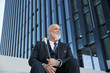 © Westend61 - Elegant businessman with walking cane, sitting on stairs in the city