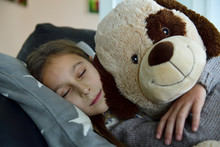 Portrait Of Girl Relaxing On Couch With Her Big Soft Toy