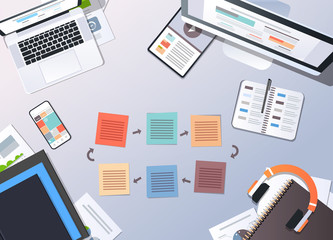 working business cyclic arrows process top angle view desktop laptop tablet smartphone screen paper documents office stuff horizontal