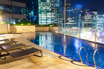 Travel destinations and hotels offering urban retreats and beautiful swimming pools at night in central city location.