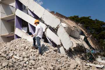 Wall Mural - Engineer holding laptop is checking for destruction, demolishing building.