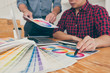 © Ngampol - Teamwork of young creative designers working on project together and choose color swatch samples for selection coloring on digital graphic tablet at workspace