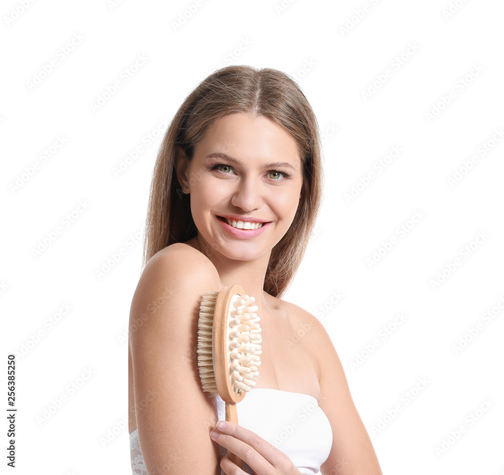 Beautiful young woman with massage brush on white background