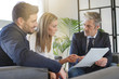 © goodluz - Couple looking over buyers agreement with real estate agent