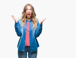 Sticker - Beautiful young blonde woman over isolated background crazy and mad shouting and yelling with aggressive expression and arms raised. Frustration concept.