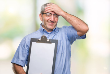 Sticker - Handsome senior inspector man holding clipboard over isolated background stressed with hand on head, shocked with shame and surprise face, angry and frustrated. Fear and upset for mistake.