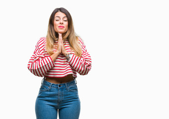 Canvas Print - Young beautiful woman casual stripes winter sweater over isolated background begging and praying with hands together with hope expression on face very emotional and worried. Asking for forgiveness. 