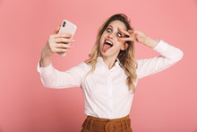 Portrait Of Cheeky Blond Woman 30s In Stylish Outfit Holding Smartphone And Taking Selfie Photo