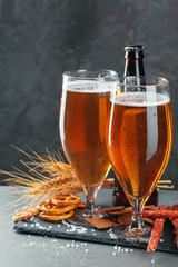  beer and appetizing beer snacks set. Table with mug of beer, wooden board with sausages