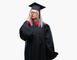 Poster - Young blonde woman wearing graduate uniform over isolated background smelling something stinky and disgusting, intolerable smell, holding breath with fingers on nose. Bad smells concept.