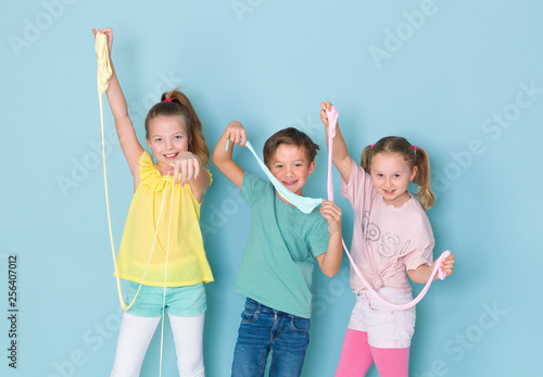Cuadros en Lienzo two beautiful and funny girls and one cool boy playing with a lot of slime in fr
