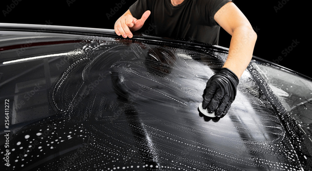A man cleaning car with microfiber cloth. Car detailing or valeting concept. Selective focus. Car detailing. Cleaning with sponge. Worker cleaning. Car wash concept solution to clean - obrazy, fototapety, plakaty 