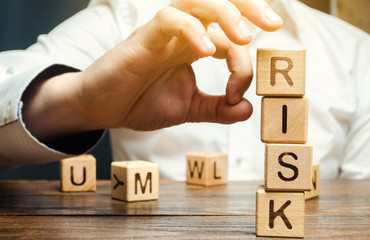 Wall Mural - hand removes blocks with the word risk. the concept of reducing possible risks. insurance, stability