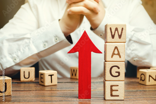 Red Arrow Up Near Wooden Blocks With The Word Wage And A